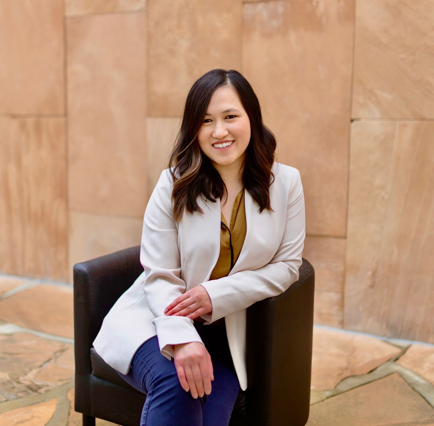 Smiling woman seated in modern chair setting.