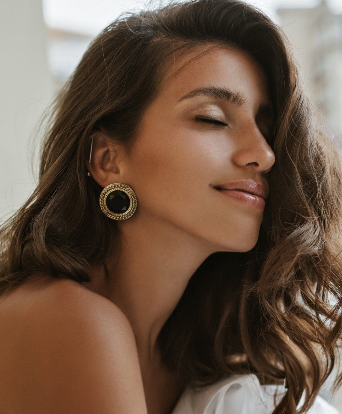 Woman with thoughtful expression and soft makeup.