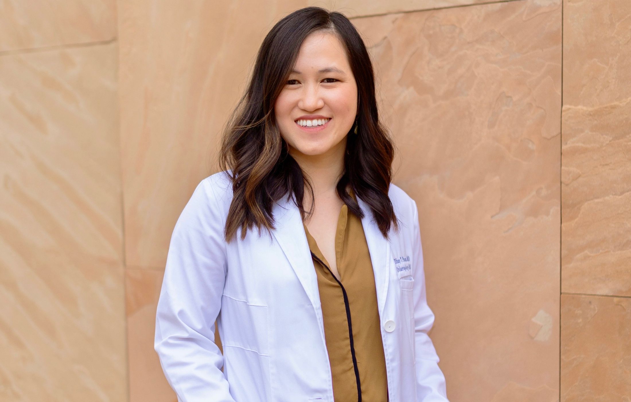 Smiling woman in a white coat.