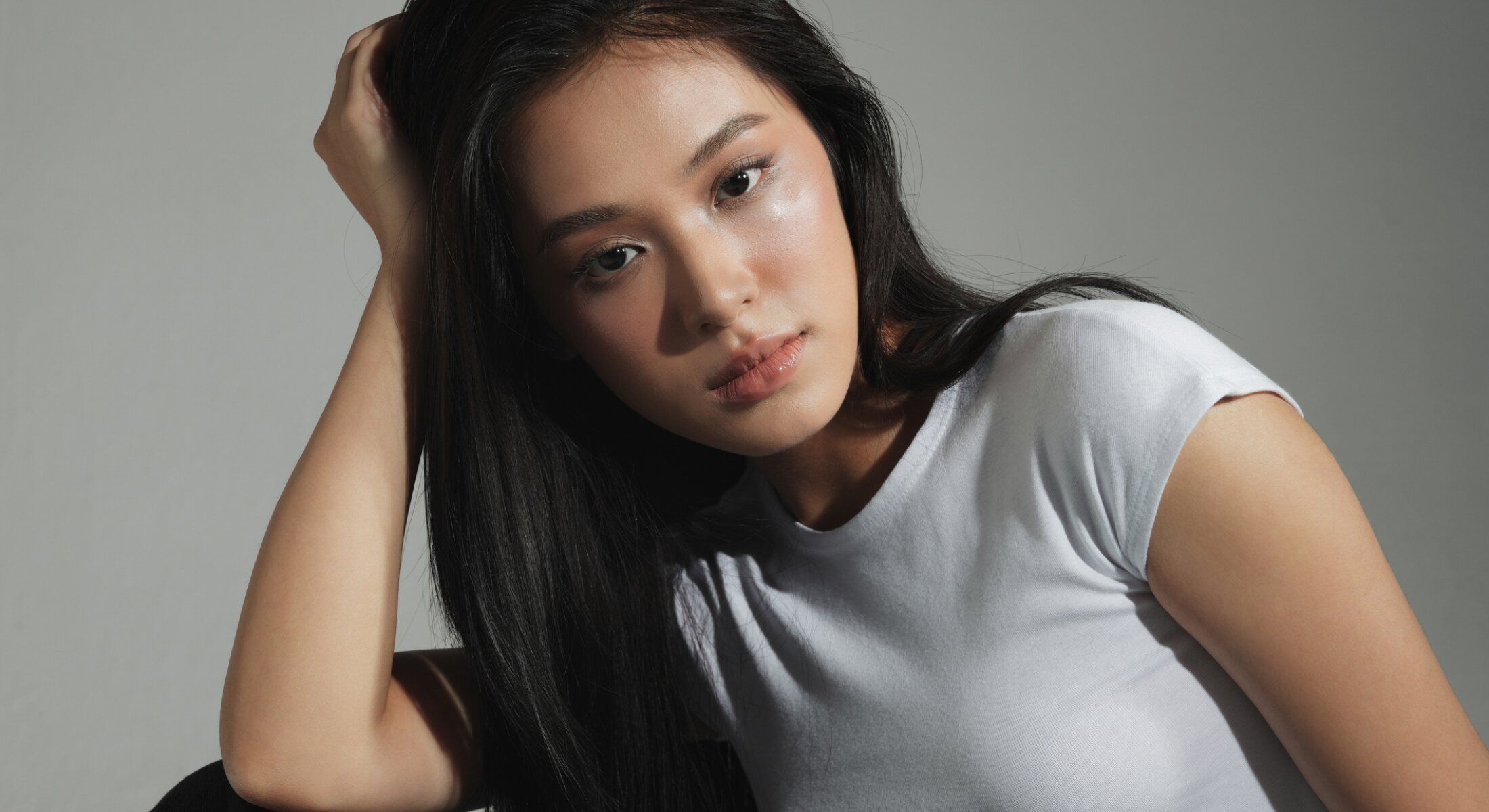 Young woman with long hair in a white shirt.