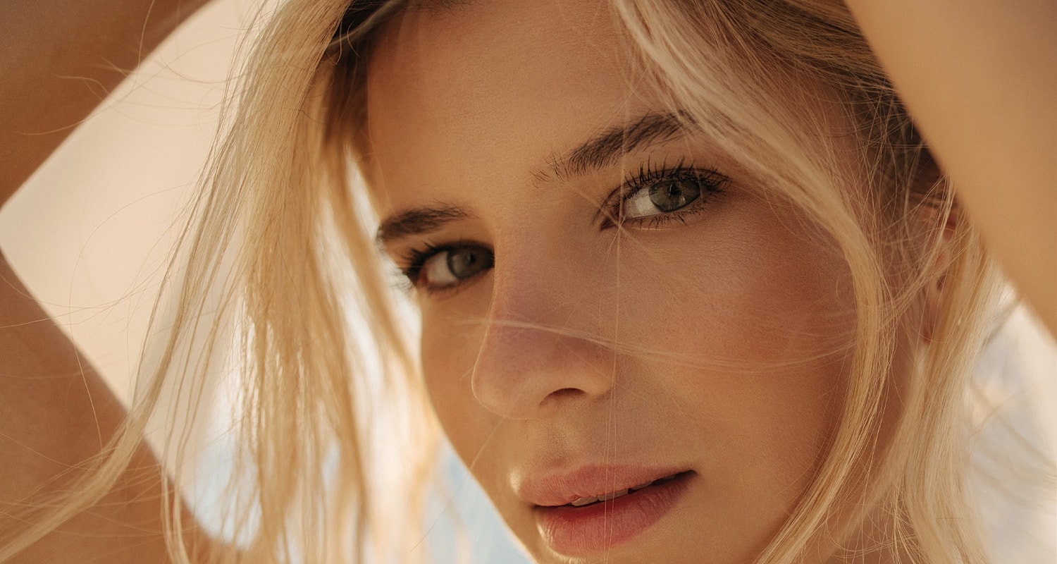 Close-up of a Beverly Hills rhinoplasty model's face with flowing hair.